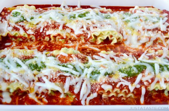 Baked Easy Pesto Lasagna Roll-Ups topped with grated Parmesan cheese