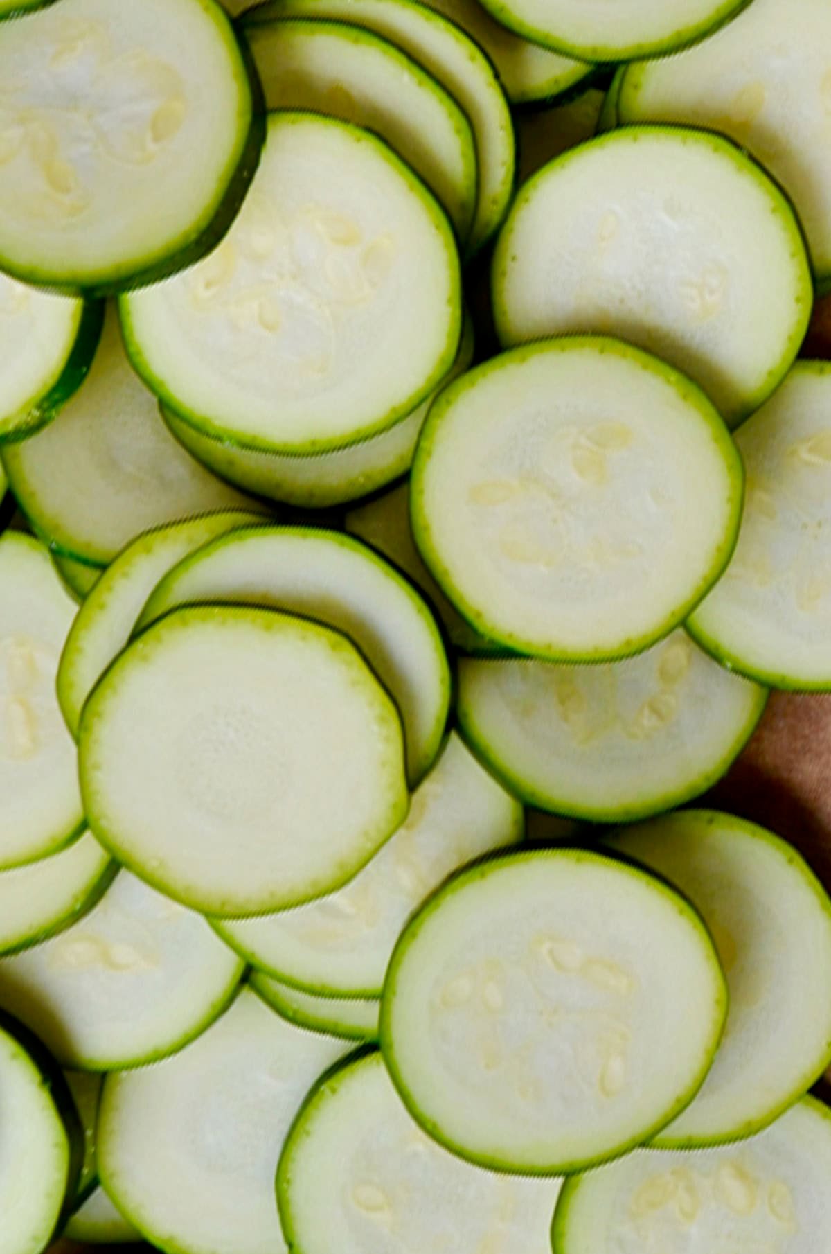 Sliced zucchini rounds on a cutting board.