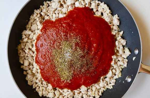 Large saucepan with ground turkey, tomato sauce and spices