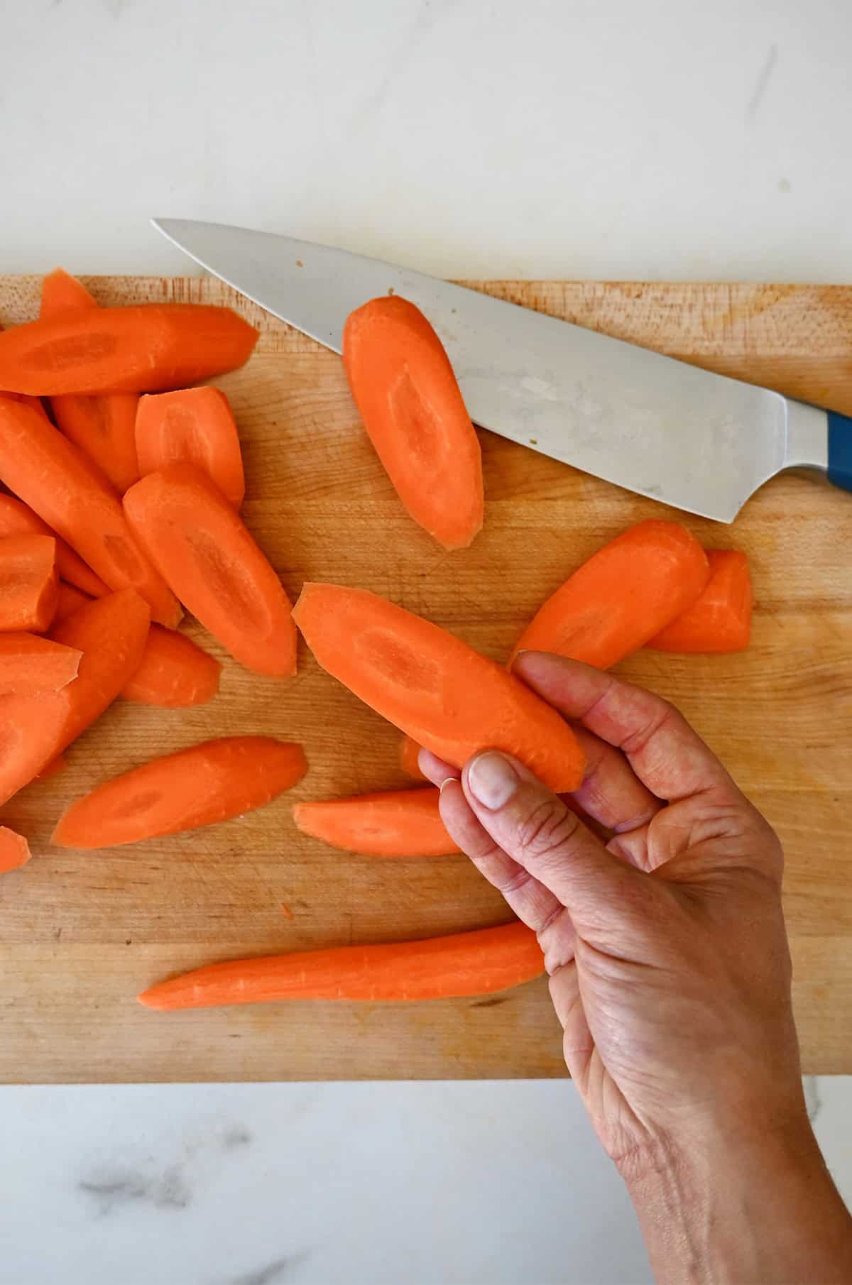 Carrots are cut on the bias into roughly 2-inch pieces that are about half an inch thick.