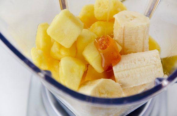 Pineapple and banana chunks with honey in blender