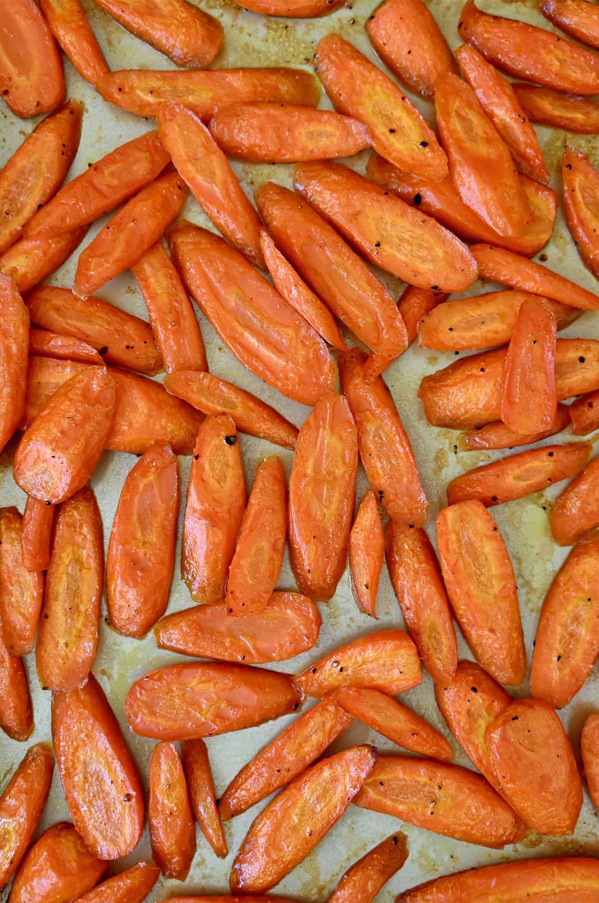 Honey glazed roasted carrots on a baking sheet.