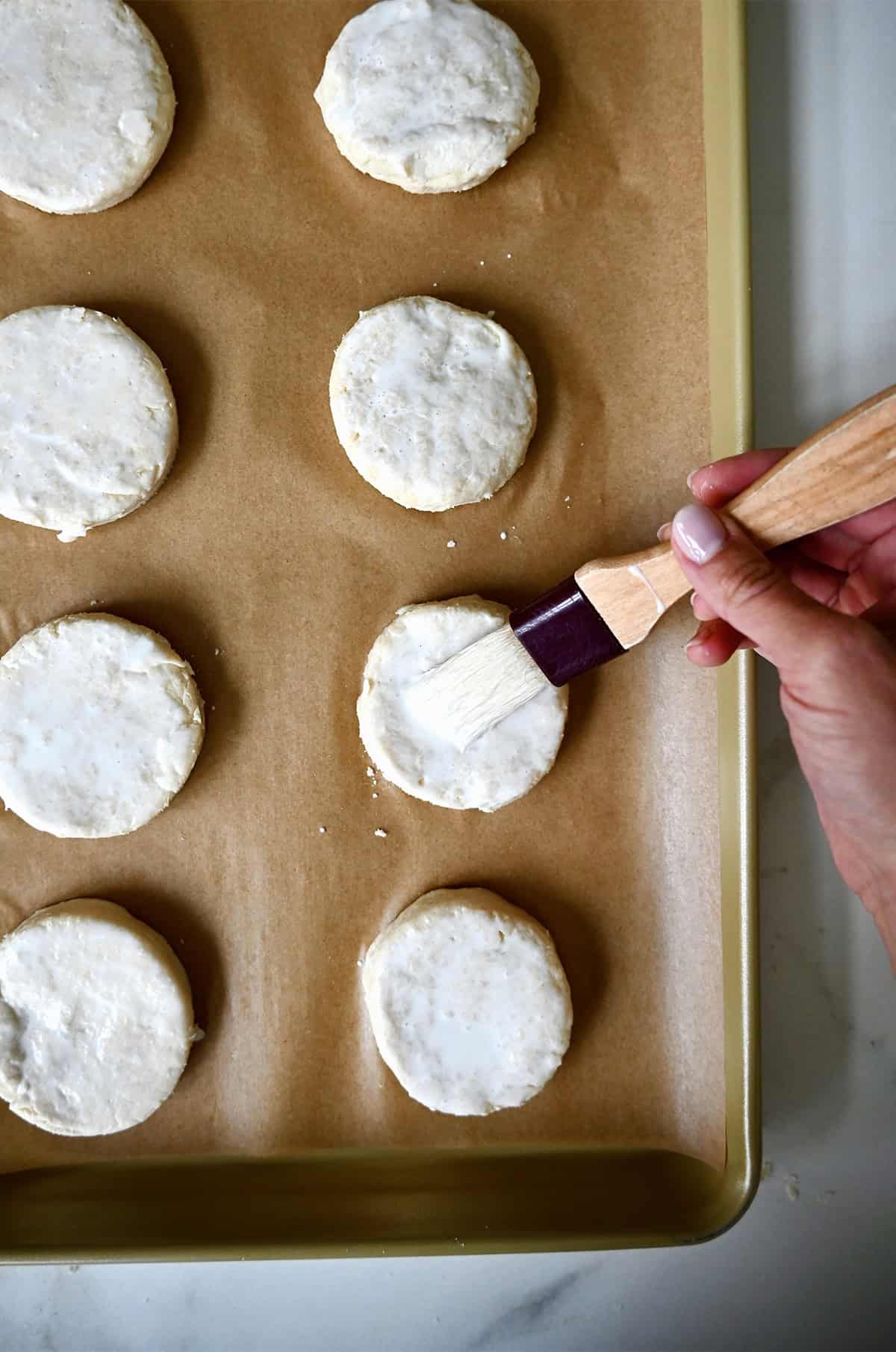 Brushing the tops of unbaked biscuits with heavy cream.