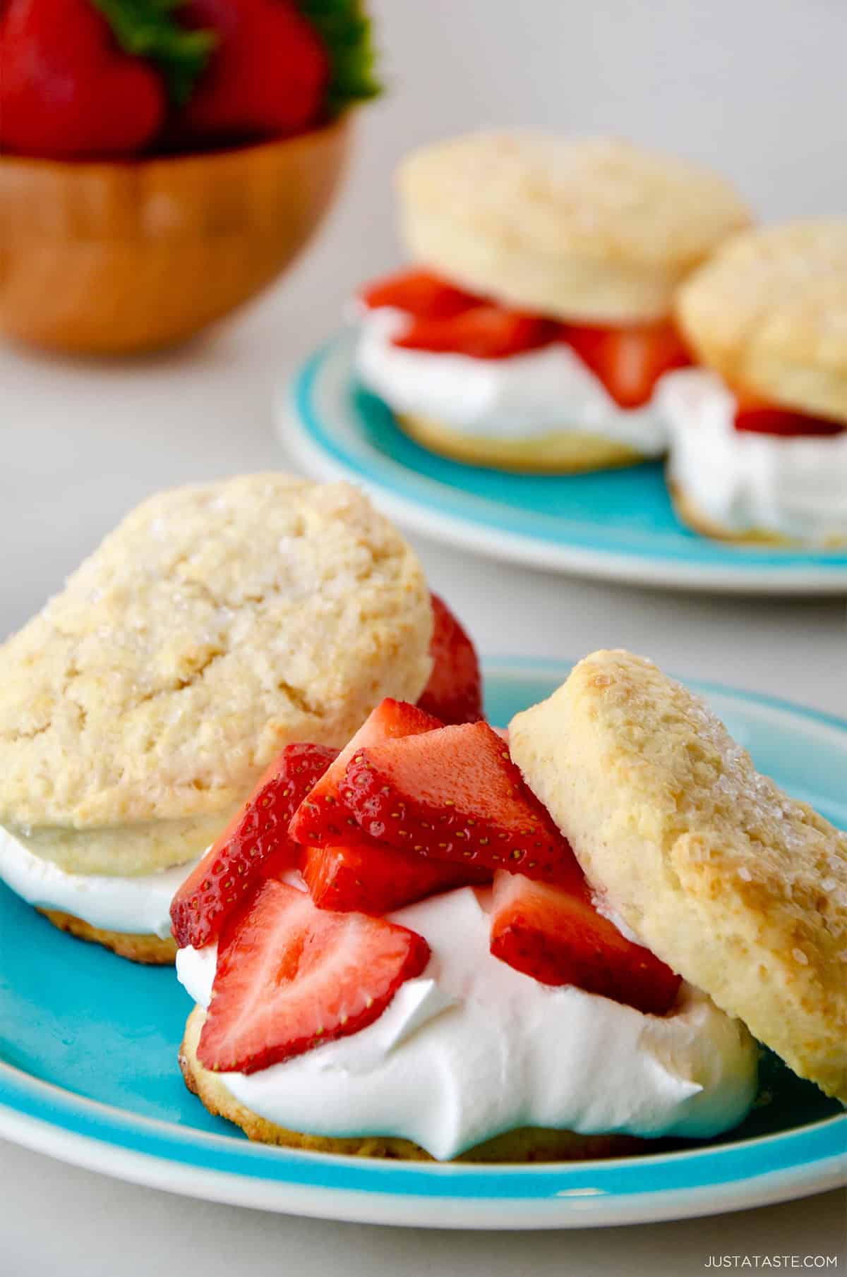 A biscuit cut in half, layered with pillowy whipped cream and juicy macerated strawberries. 