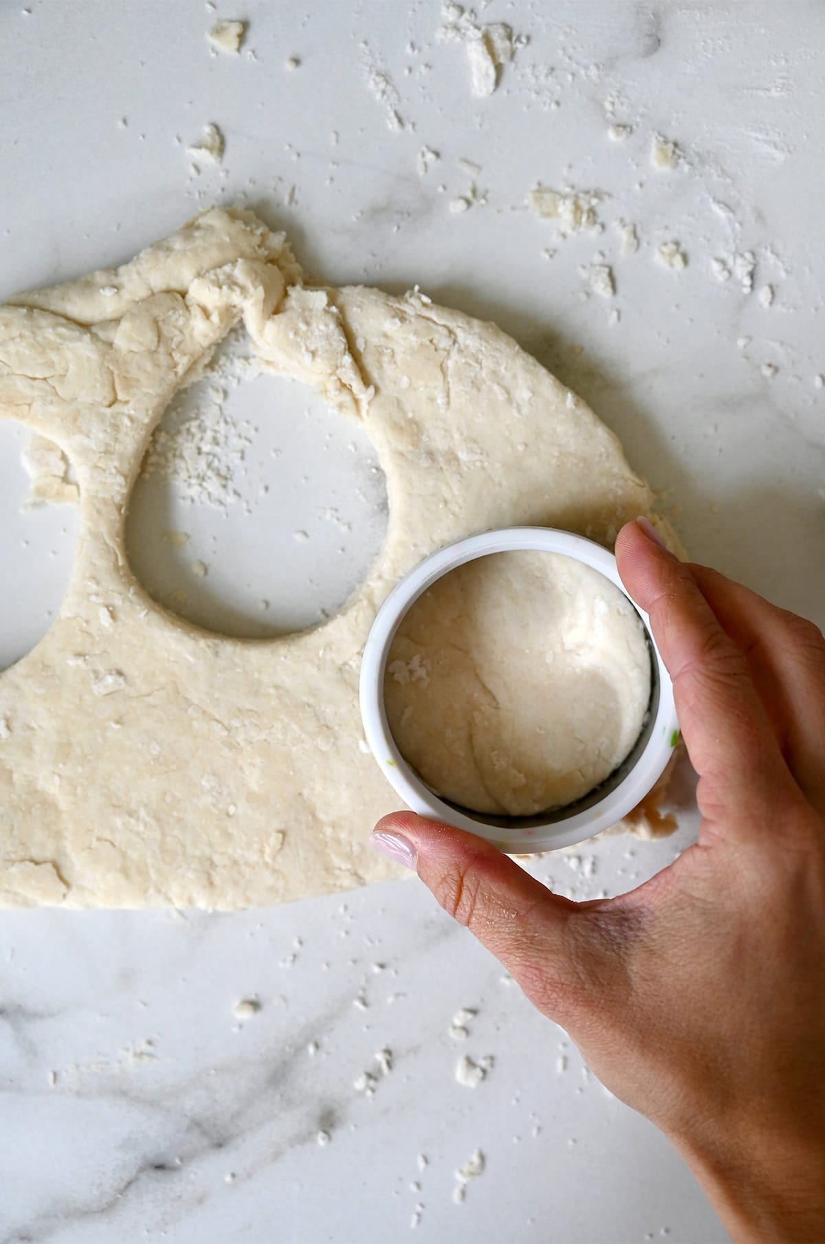 Punching out shortcake dough with a round biscuit cutter.