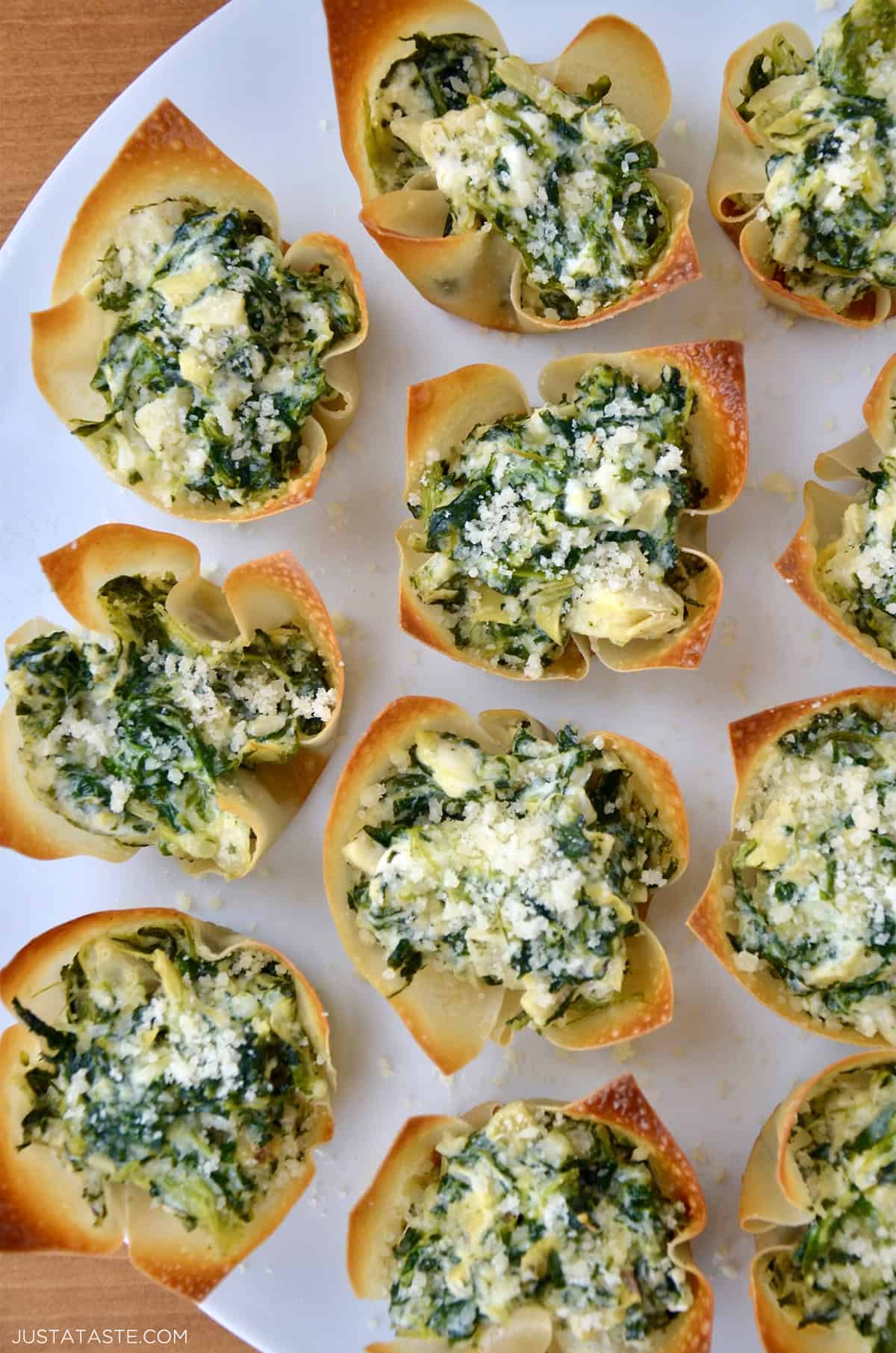 A top-down view of spinach artichoke dip wonton cups on a serving platter.