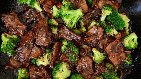 A large skillet containing beef and broccoli coated in a garlicky soy sauce.