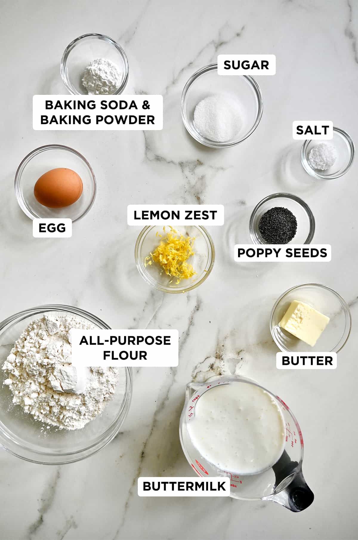 Various sizes of bowls containing the simple ingredients needed to make lemon poppyseed pancakes.