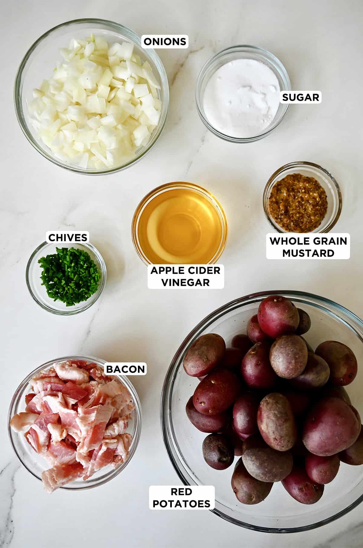 Ingredients to make potato salad with a bacon and mustard dressing.