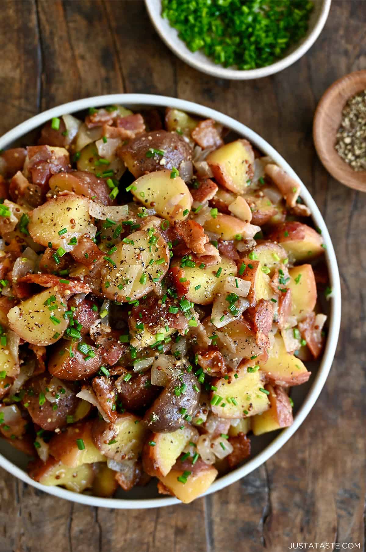 German potato salad with warm bacon dressing in a large serving bowl.