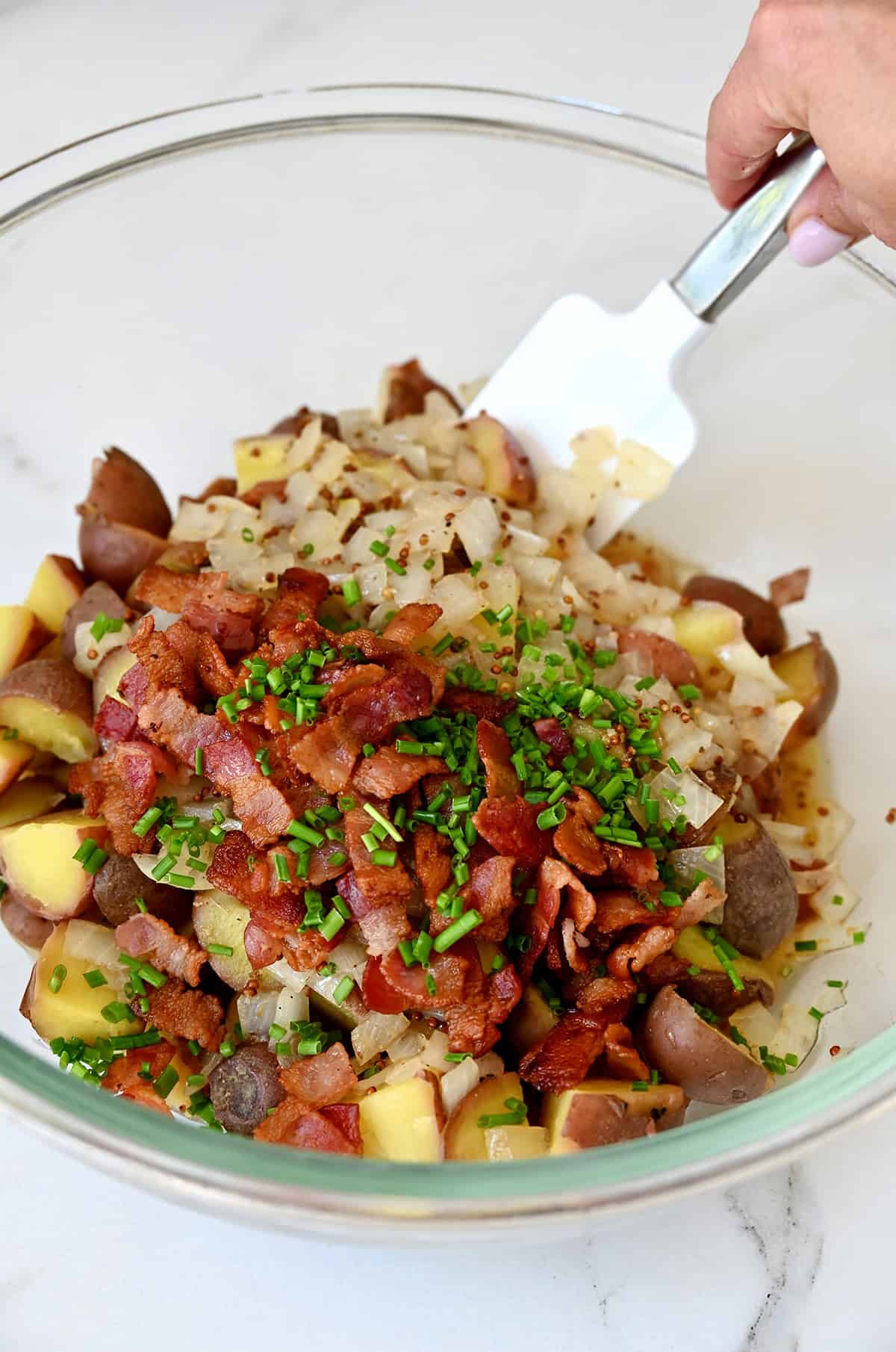 German potato salad with bacon pieces and fresh chives, tossed in a warm mustard-and-bacon dressing.