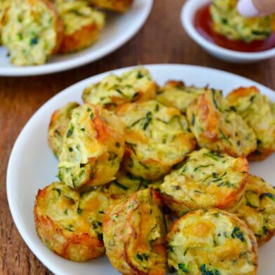 Pile of Cheesy Baked Zucchini Tots on white plate