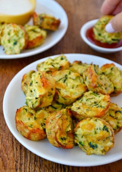 Pile of Cheesy Baked Zucchini Tots on white plate