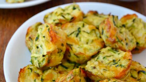 Pile of Cheesy Baked Zucchini Tots on white plate