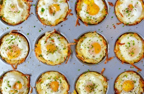 Baked Cheesy Hash Brown Cups topped with chives in muffin tin 