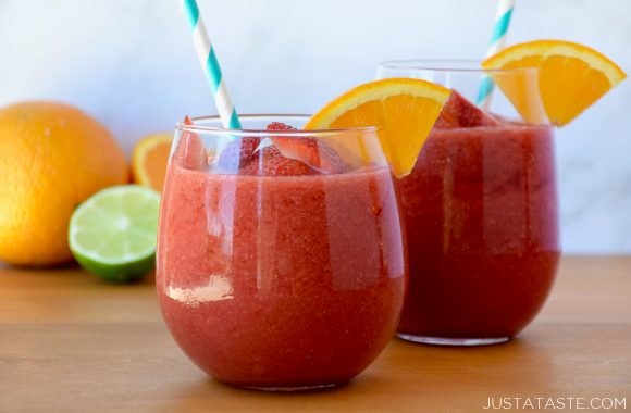 Two wine glasses with The Best Frozen Sangria served with an orange garnish