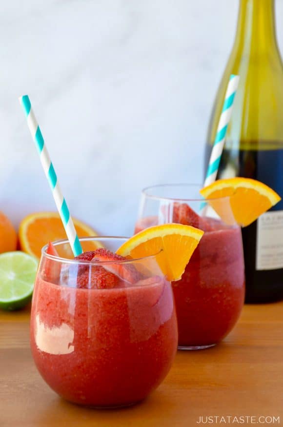 The Best Frozen Sangria with an orange slice and teal stripped straw