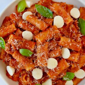 One Pot Pasta with Italian Sausage in white bowl with fresh mozzarella and basil