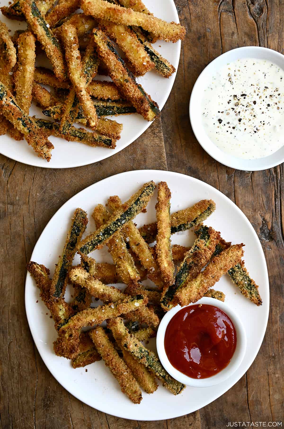 Crispy zucchini fries on a plate with a small bowl containing ketchup.