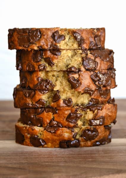Slices of chocolate chunk banana bread stack atop each other.