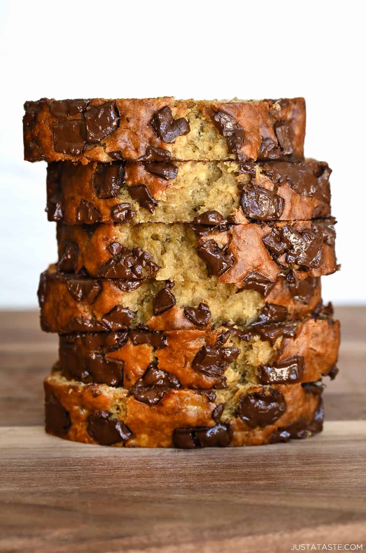 Slices of chocolate chunk banana bread stack atop each other. 