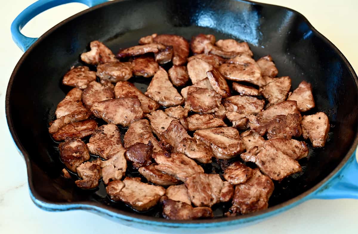 Browned pork pieces in a large skillet.