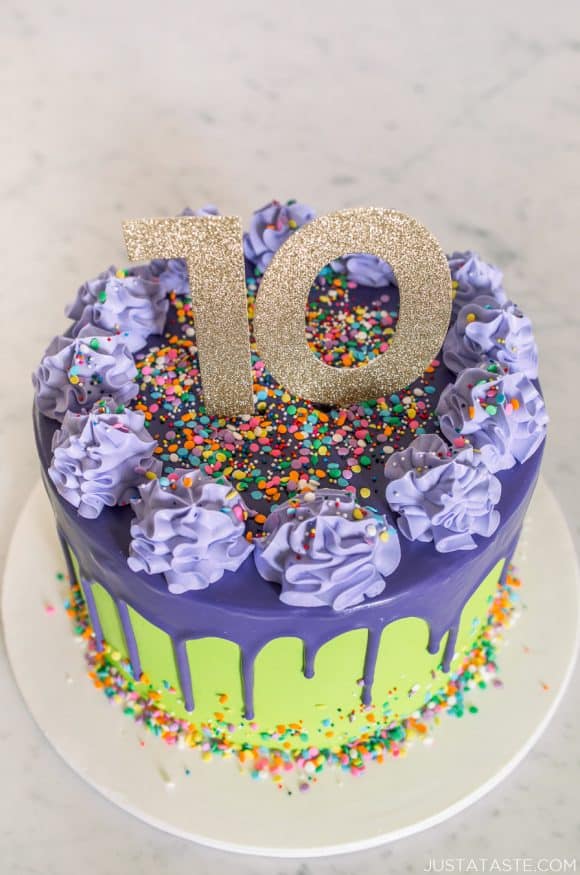 A purple and green 10-year anniversary cake with drips and sprinkles