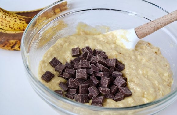 Sour Cream Chocolate Chunk Banana Bread mixture with chocolate chunks and spatula