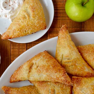 Easy Apple Turnovers on serving plate next to a small bowl with whipped cream