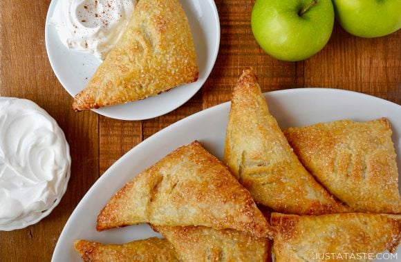 Easy Apple Turnovers on serving plate next to a small bowl with whipped cream 