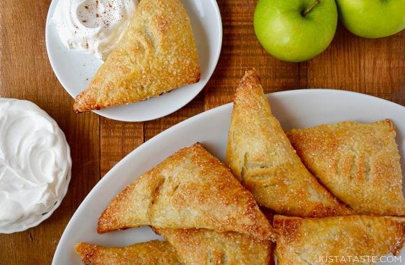 Easy Apple Turnovers on serving plate next to a small bowl with whipped cream