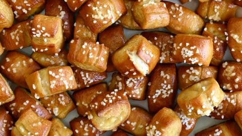 A close-up view of Easy Homemade Soft Pretzel Bites surrounding a small ramekin filled with yellow mustard