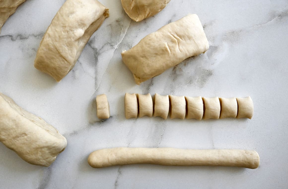 A top-down view of rolled dough next to more dough cut into small pieces