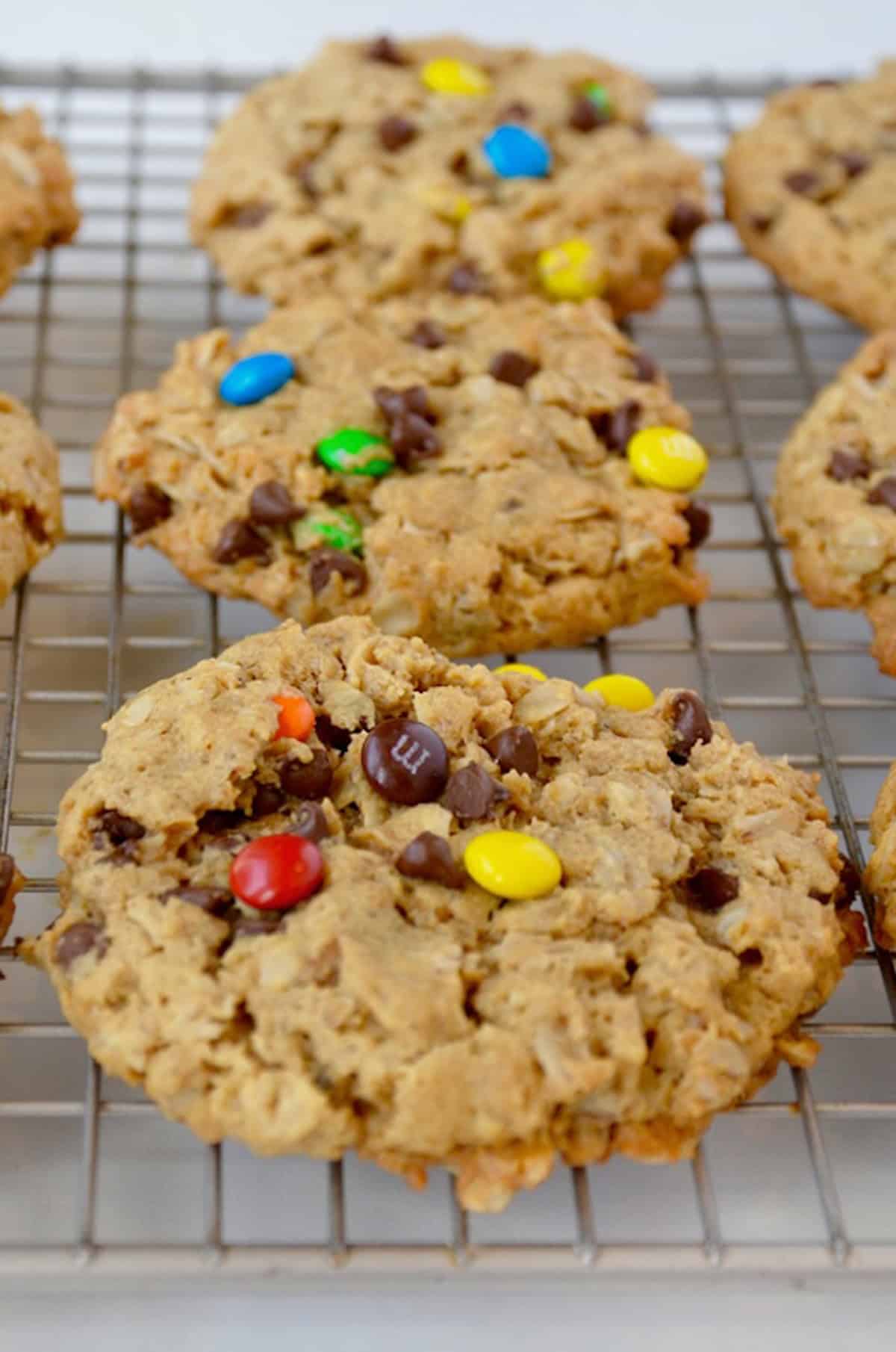 Baked monster cookies cooling on a wire rack.