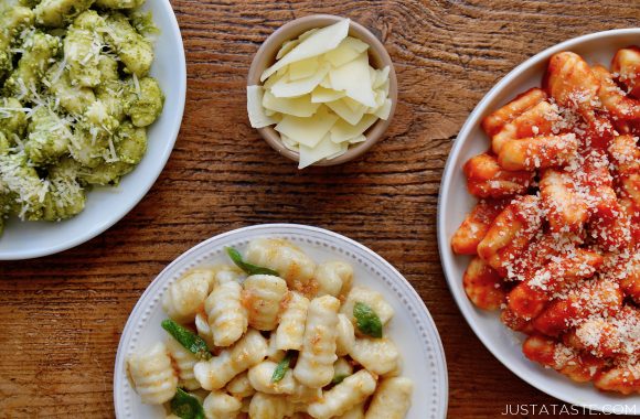 A brown wood table with three plates of Mashed Potato Gnocchi