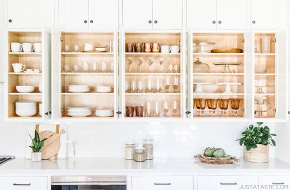 White cabinets filled with plates, cups and bowls all lined up