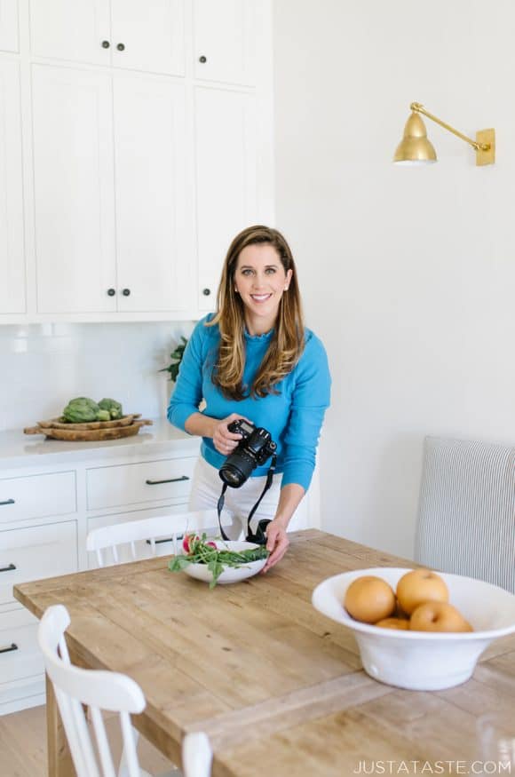 Kelly Senyei standing in her kitchen photographing food