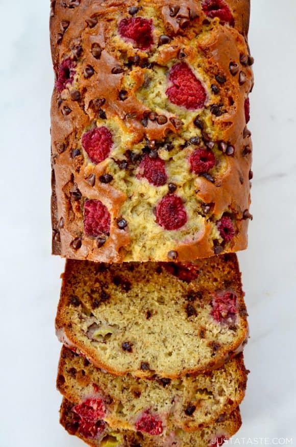 A top down view of a loaf of Raspberry Chocolate Chip Banana Bread cut into slices