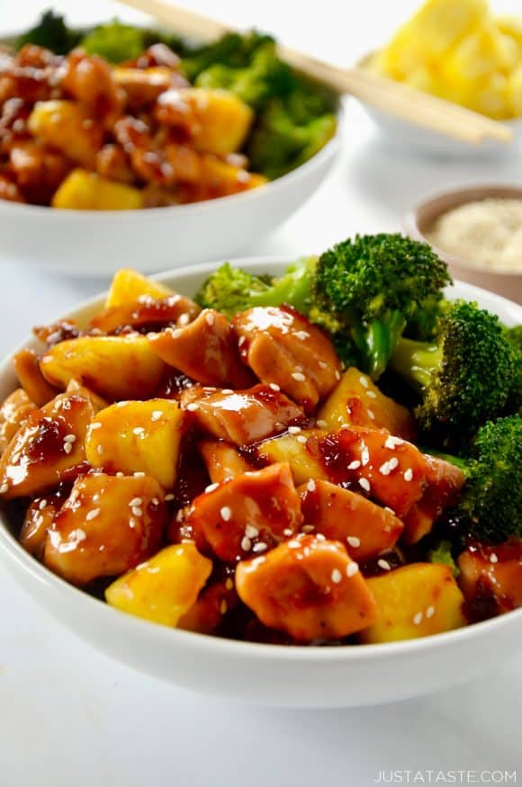 White bowl containing Sheet Pan Pineapple Chicken and Broccoli garnished with sesame seeds