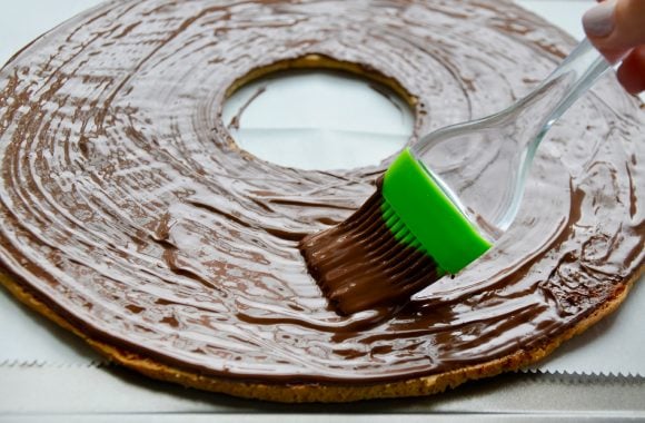 Brushing cookie cake with melted chocolate