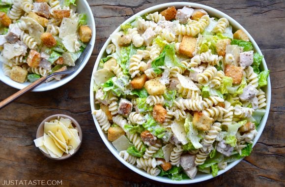 A top down view of a large bowl and a small bowl containing Chicken Caesar Pasta Salad