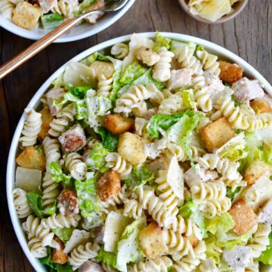 A top down view of a bowl containing the best Chicken Caesar Pasta Salad