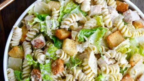 A top down view of a bowl containing the best Chicken Caesar Pasta Salad