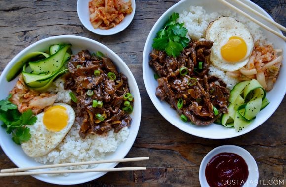 Top down view of Easy Beef Bulgogi Bowls with a fried egg, cucumber ribbons, white rice, fresh cilantro and kimchi