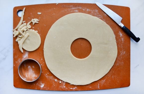 Cutting board with round cookie cutter, samoas cookie dough and knife