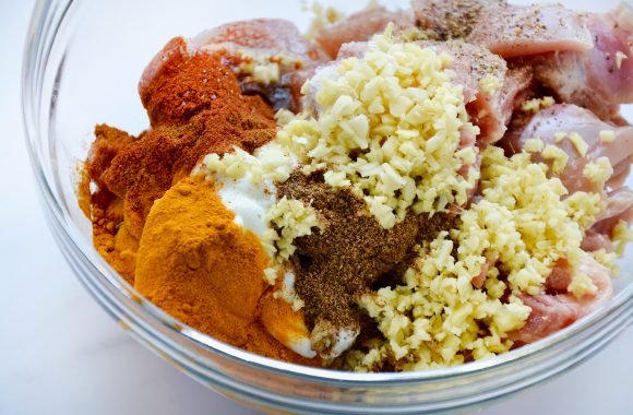 Clear bowl containing chicken tikka masala marinade ingredients 