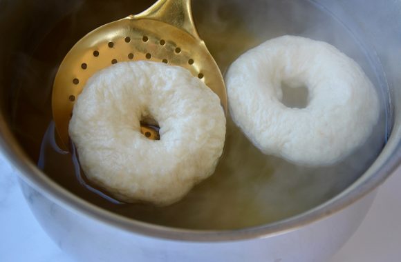 A large pot filled with water and homemade bagels