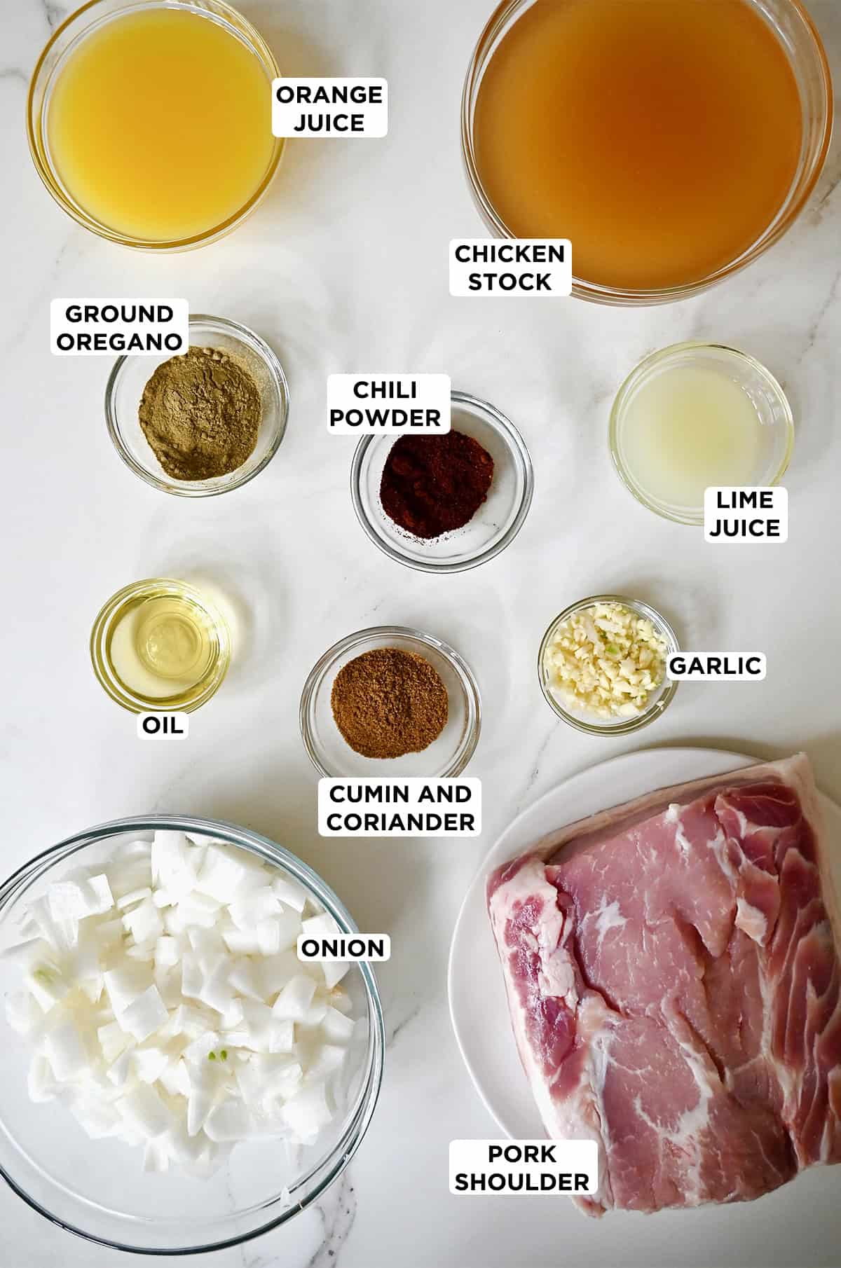 Ingredients to make traditional carnitas, including pork shoulder, citrus juices, onion, chicken stock and plenty of spices.