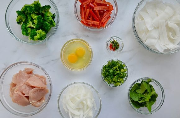 Small glass bowls containing drunk noodles ingredients