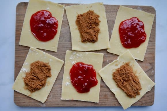 Wood cutting board with alternating strawberry and cinnamon filled pop tarts 